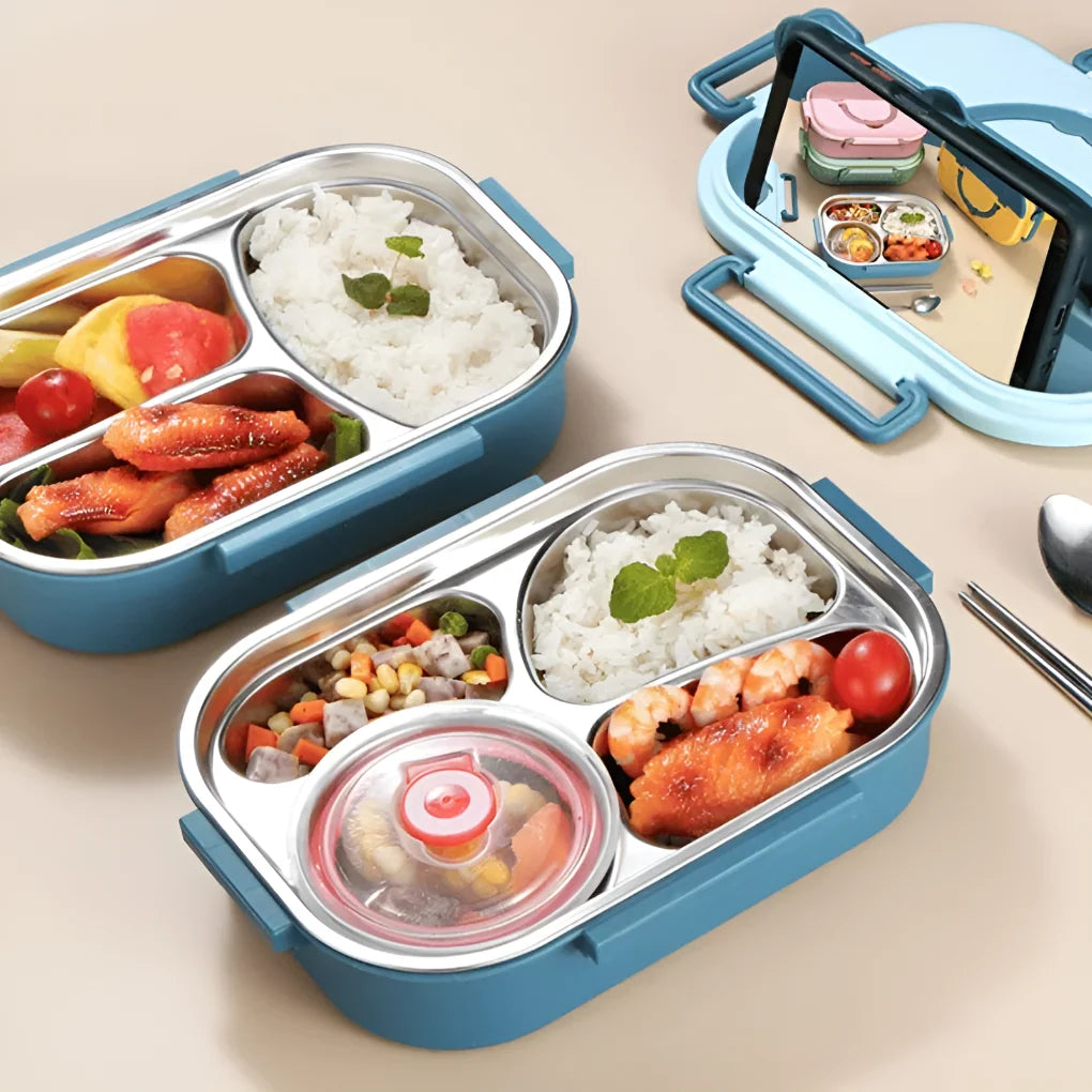Multi-compartment stainless steel lunch box with pastel pink exterior and leak-resistant lid on white surface