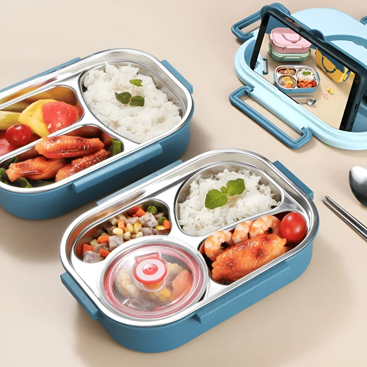 Multi-compartment stainless steel lunch box with pastel pink exterior and leak-resistant lid on white surface