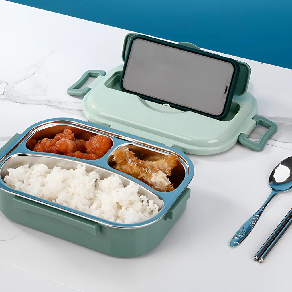 Close-up of stainless steel lunch box compartments holding rice, breaded protein, and vegetables with silicone seal visible