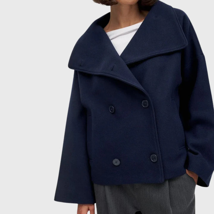 Close-up of women's double breasted coat showing wide lapel collar and button detail