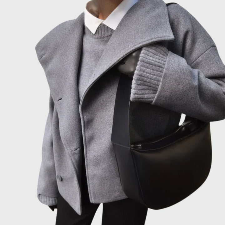 Women's black cropped coat styled over ribbed knitwear and dark trousers