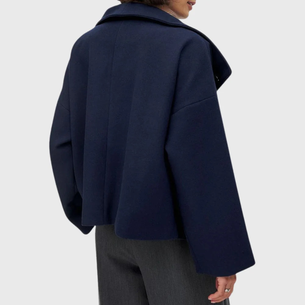 Women's cropped double breasted coat worn open over black jumper and trousers