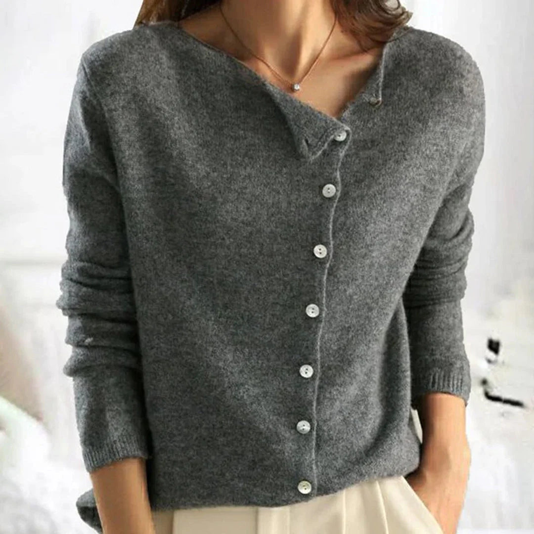 Close-up view of diagonal button placket detail on women's knit cardigan with pearlescent buttons