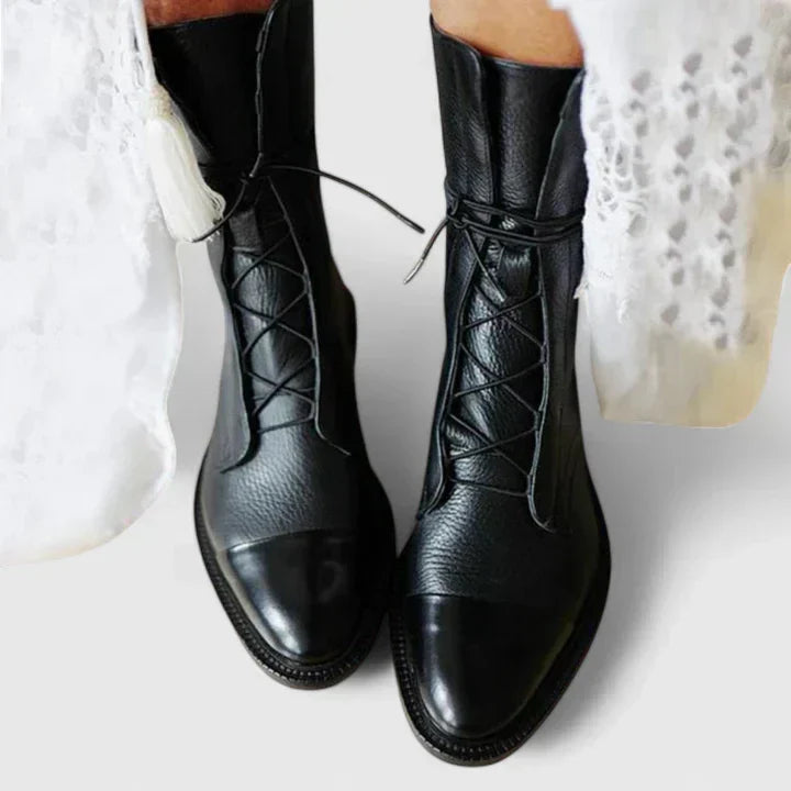 Close-up of women's ankle boots showing front lacing detail and rounded toe shape