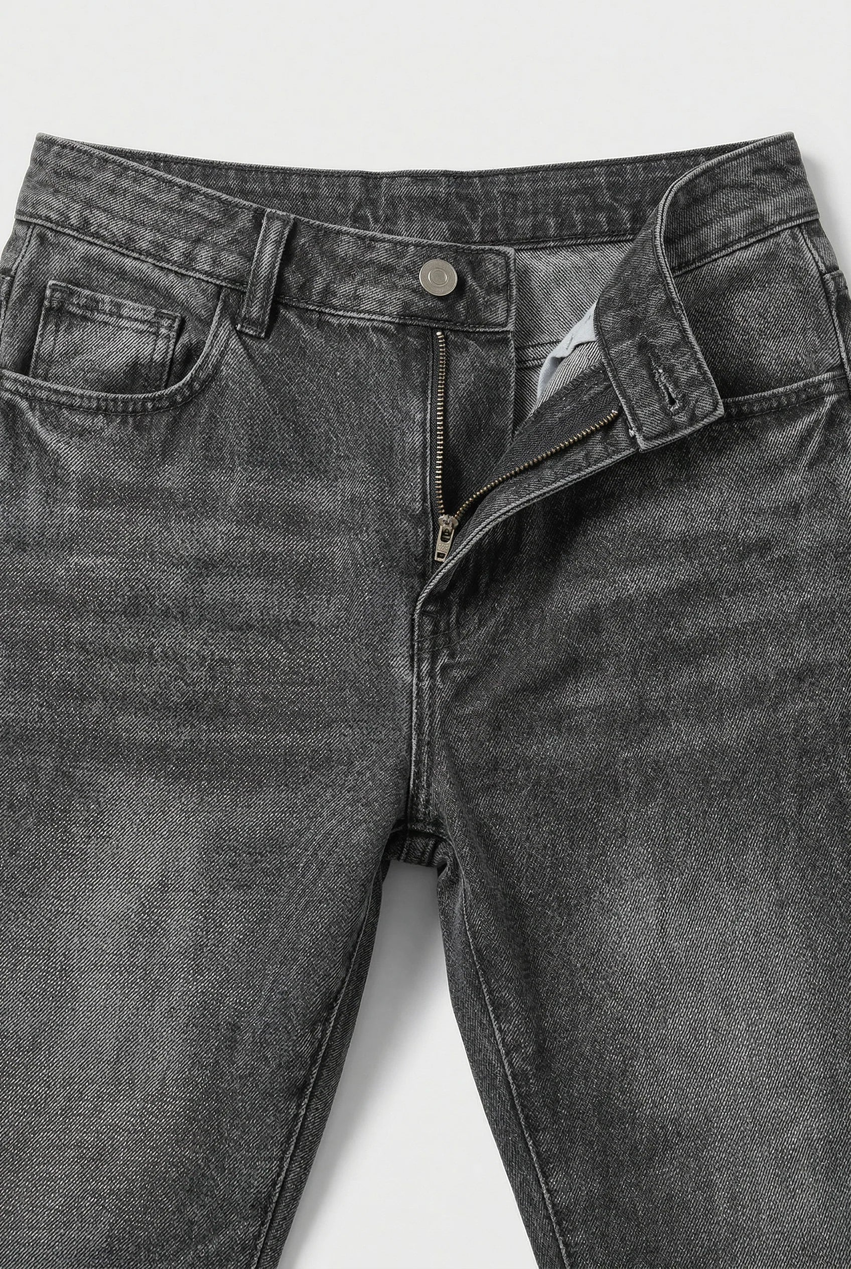 Close-up of men's loose fit jeans waistband with button closure and belt loops