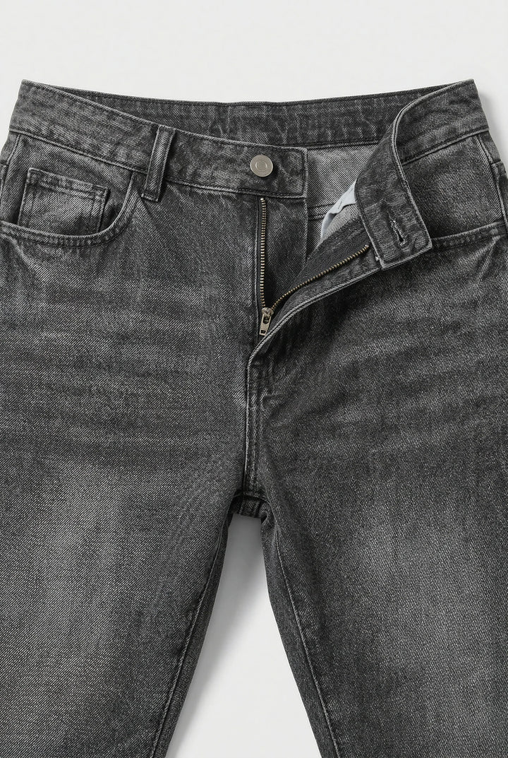 Close-up of men's loose fit jeans waistband with button closure and belt loops