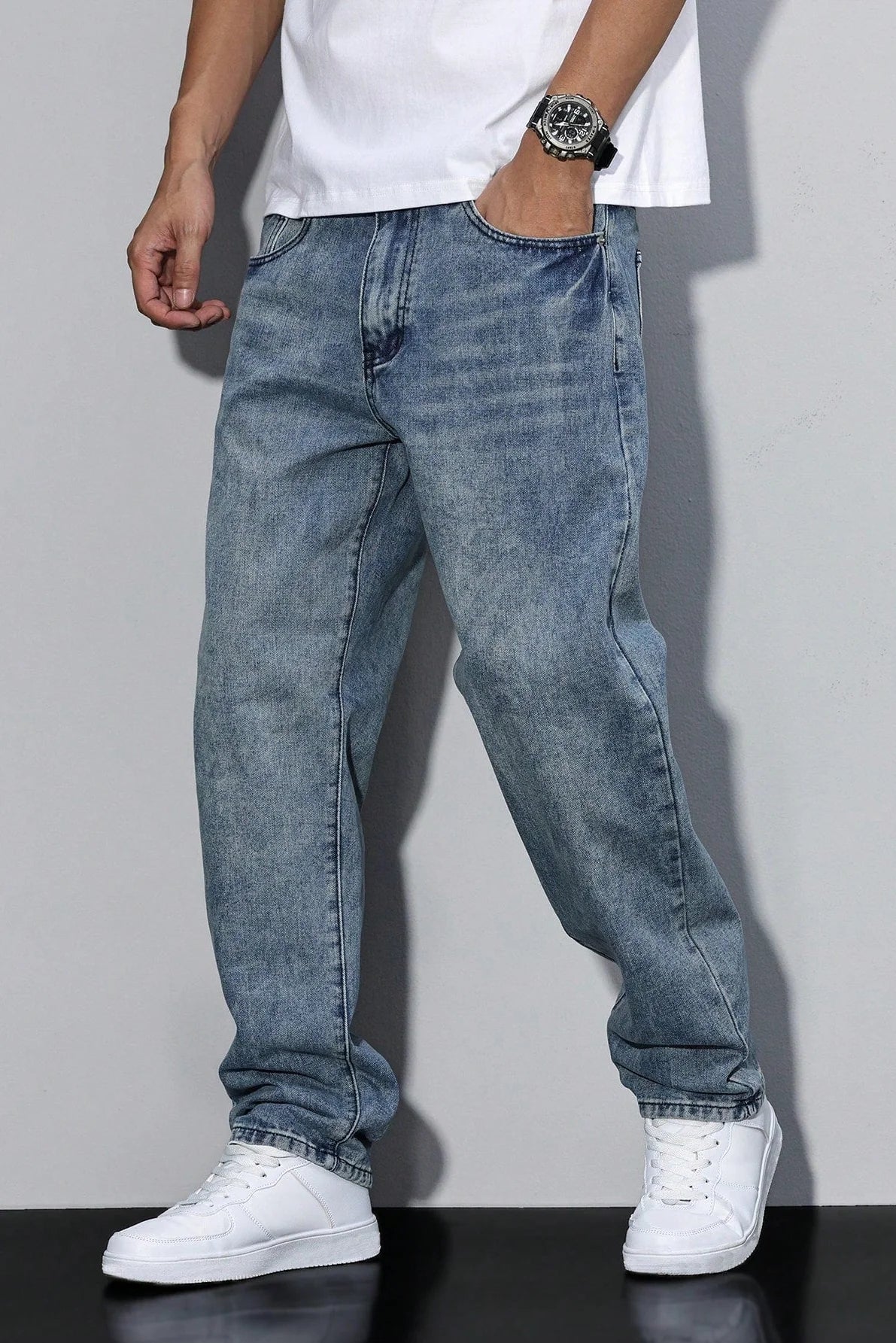 Men's relaxed fit jeans styled with white t-shirt showing comfortable loose silhouette