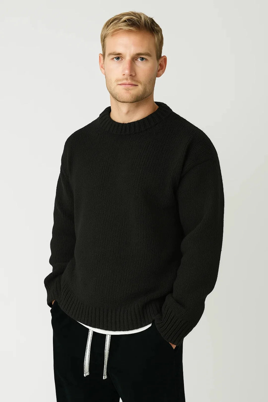 Man wearing black ribbed crew neck jumper with relaxed fit and textured knit construction