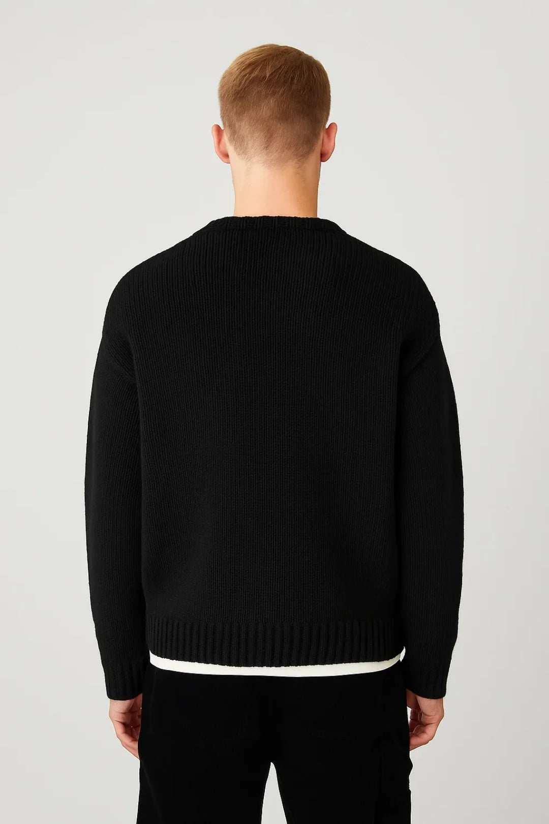 Close-up view of men's ribbed jumper showing textured knit pattern and crew neckline detail