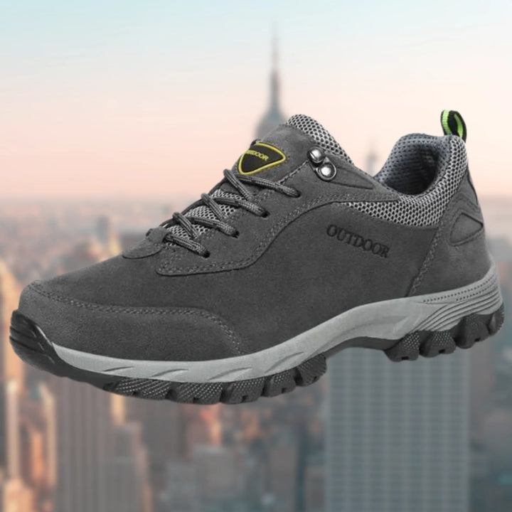 Close-up of men's walking trainers highlighting reinforced stitching and pull tab at heel