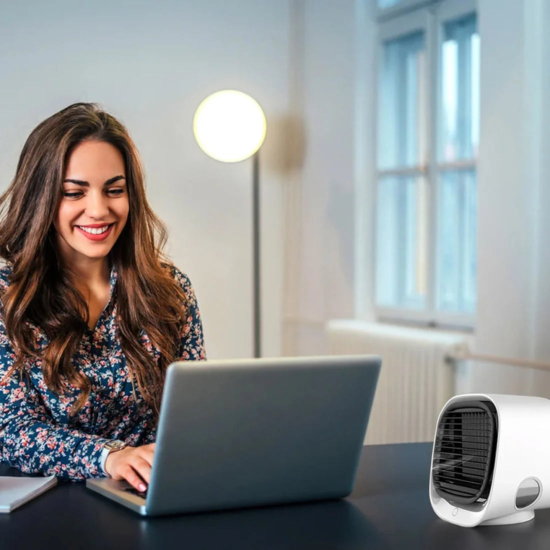 Compact cube-shaped evaporative air cooler featuring rounded edges and single control button for desktop use