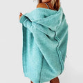 Women's knee-length hooded cardigan styled over casual outfit with white handbag