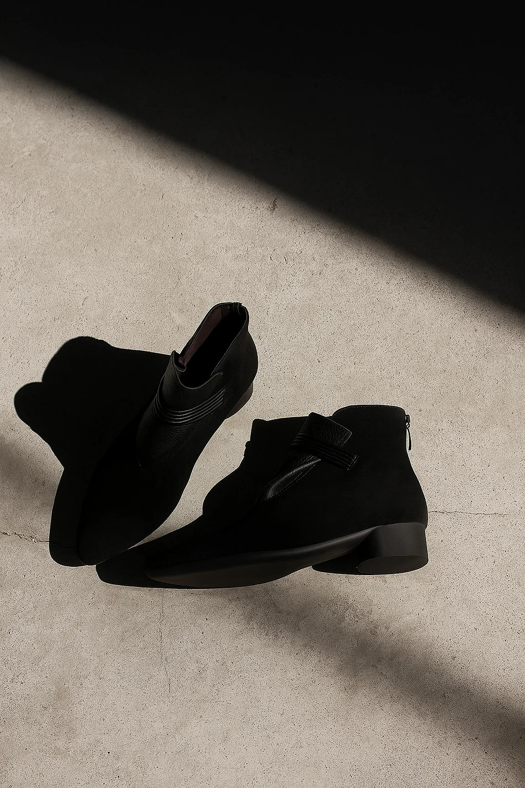 Close-up of ankle strap detail and suede construction on women's boots