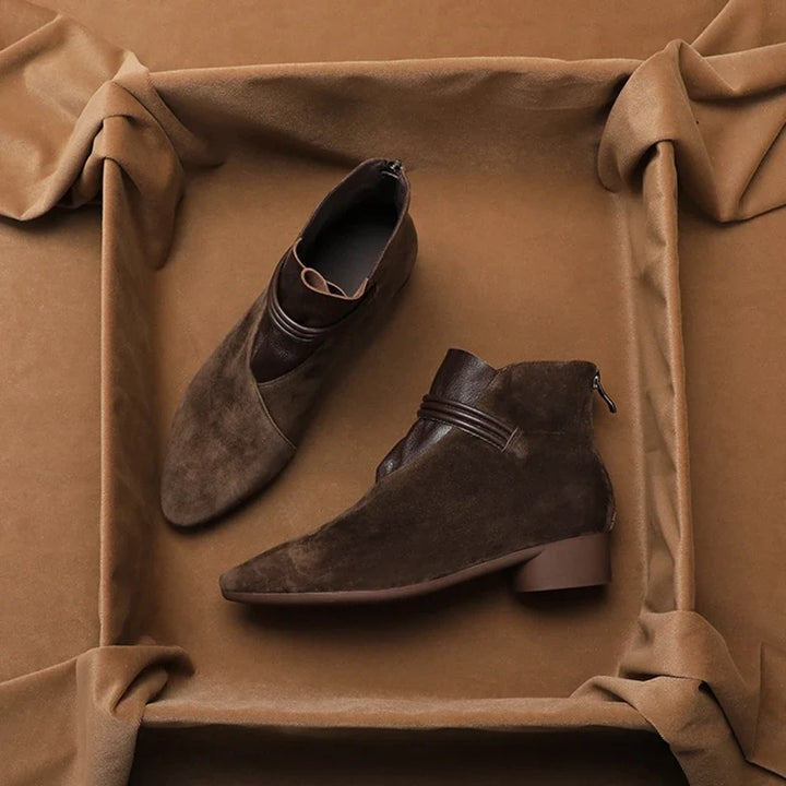 Women's suede ankle boots in coffee brown shade on neutral background