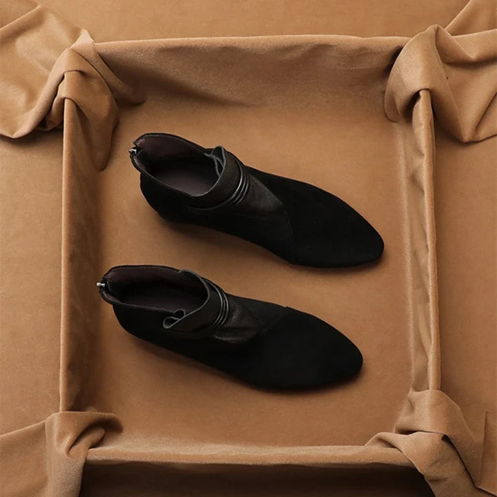 Women's suede ankle boots in black showing side-zip and heel detail