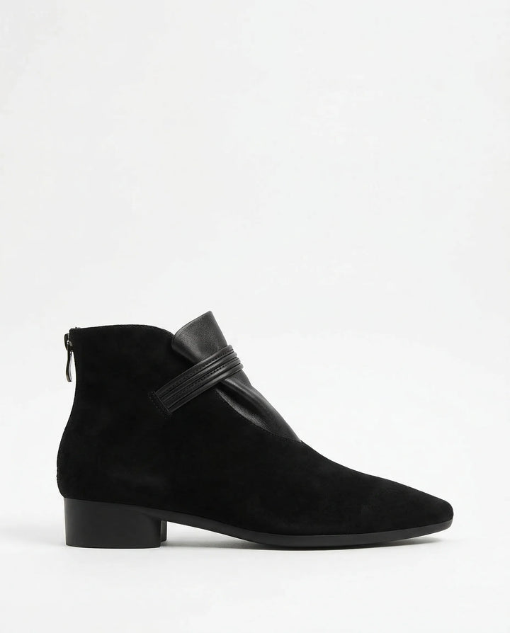 Side view of women's suede ankle boots showing side-zip closure and block heel detail