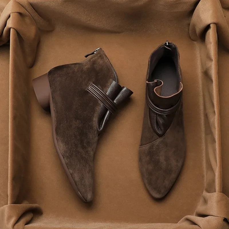 Close-up of suede ankle boots featuring pointed-toe design and smooth suede finish