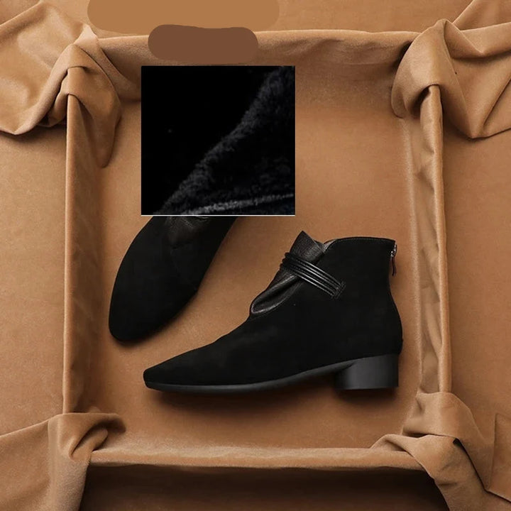 Close-up of low block heel and sole construction on ankle boots