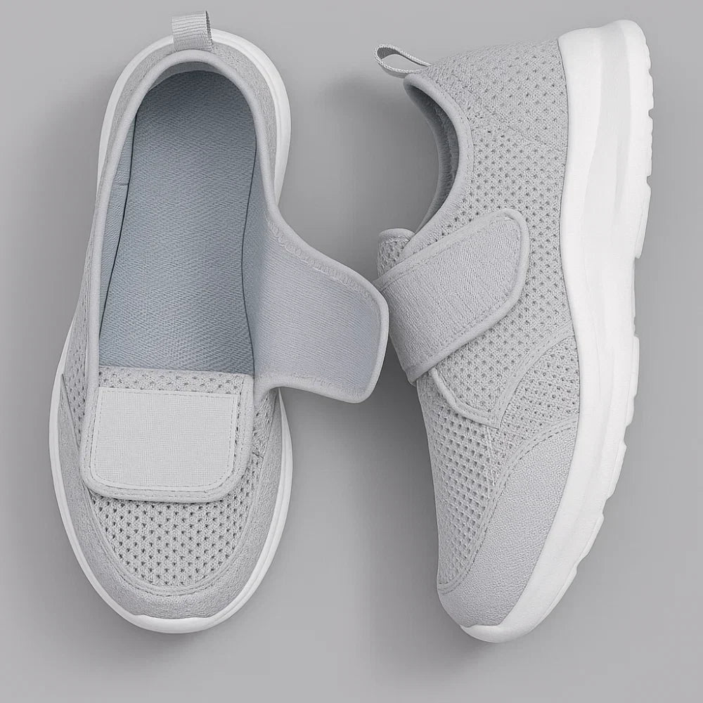 Close-up of grey women's wide fit trainers showing perforated upper detail and hook-and-loop strap closure