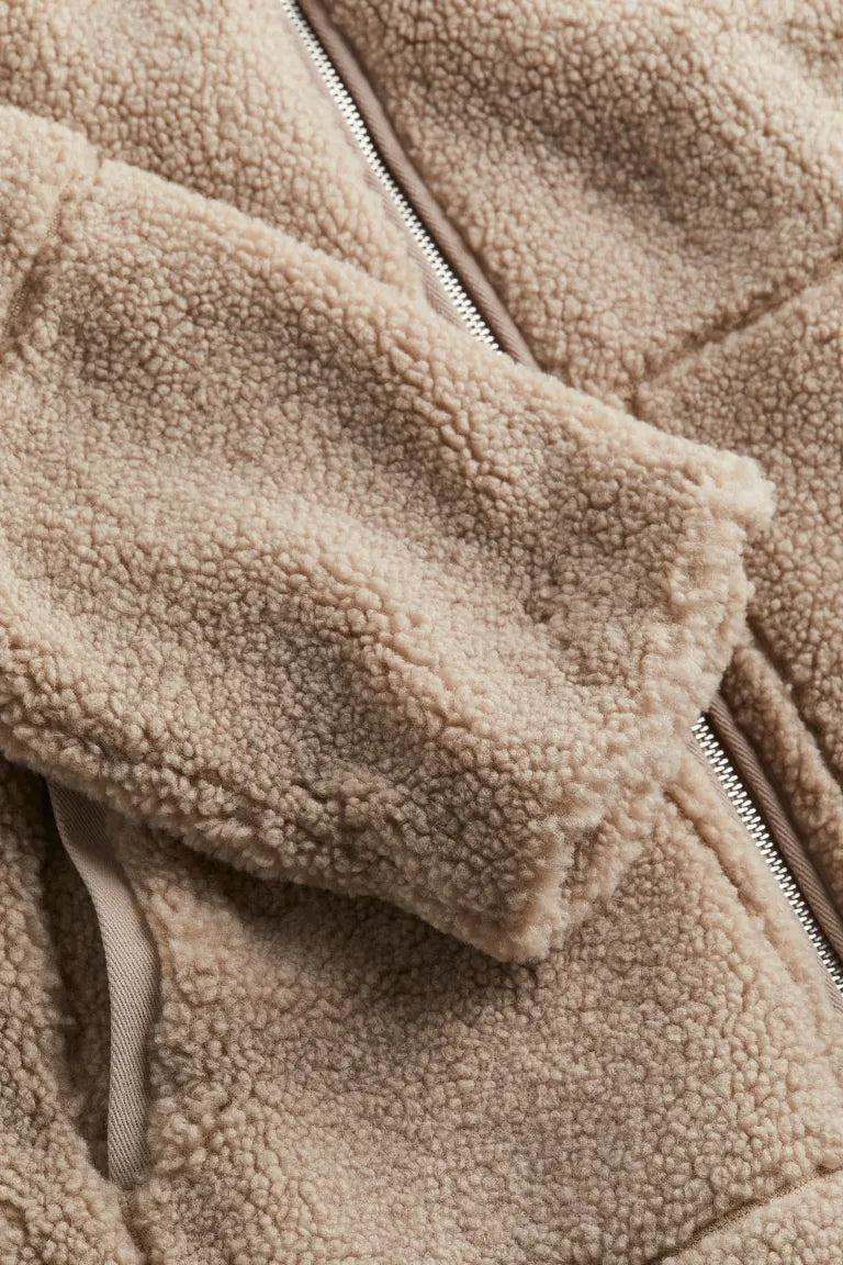 Detail of the full-length zip closure and high funnel neck on the women's teddy jacket