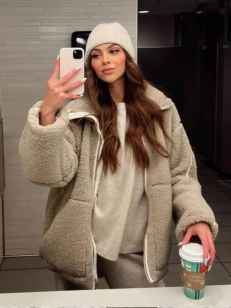 Woman styling the cream teddy fleece jacket with black leggings for casual wear