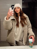 Woman styling the cream teddy fleece jacket with black leggings for casual wear