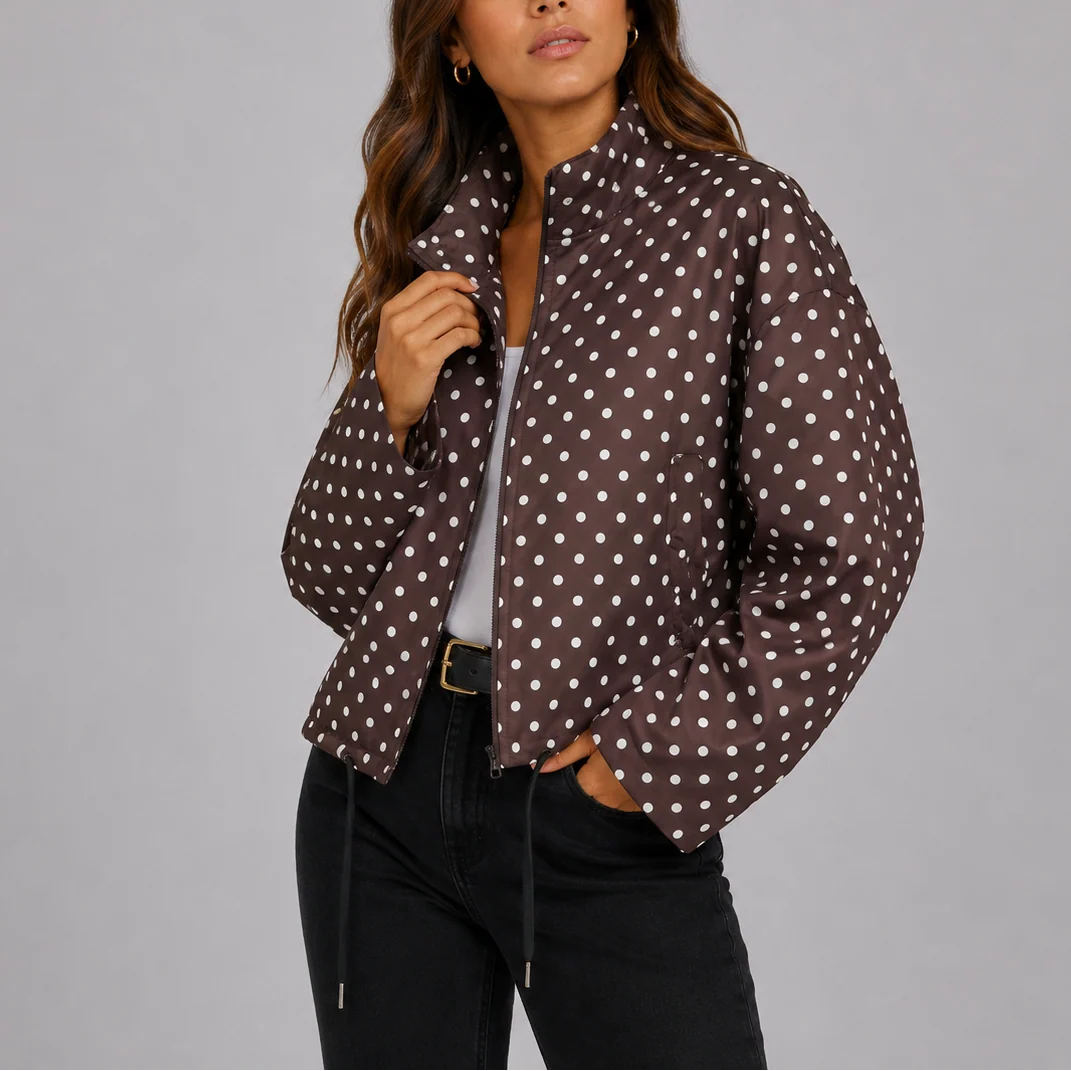 Side view of relaxed fit polka dot bomber jacket with drawstring hem and ribbed cuffs