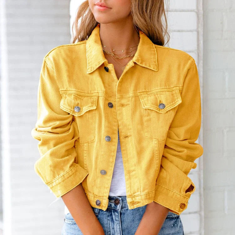 Close-up of women's cropped denim jacket showing button-up front with silver-tone fastenings and structured chest pockets