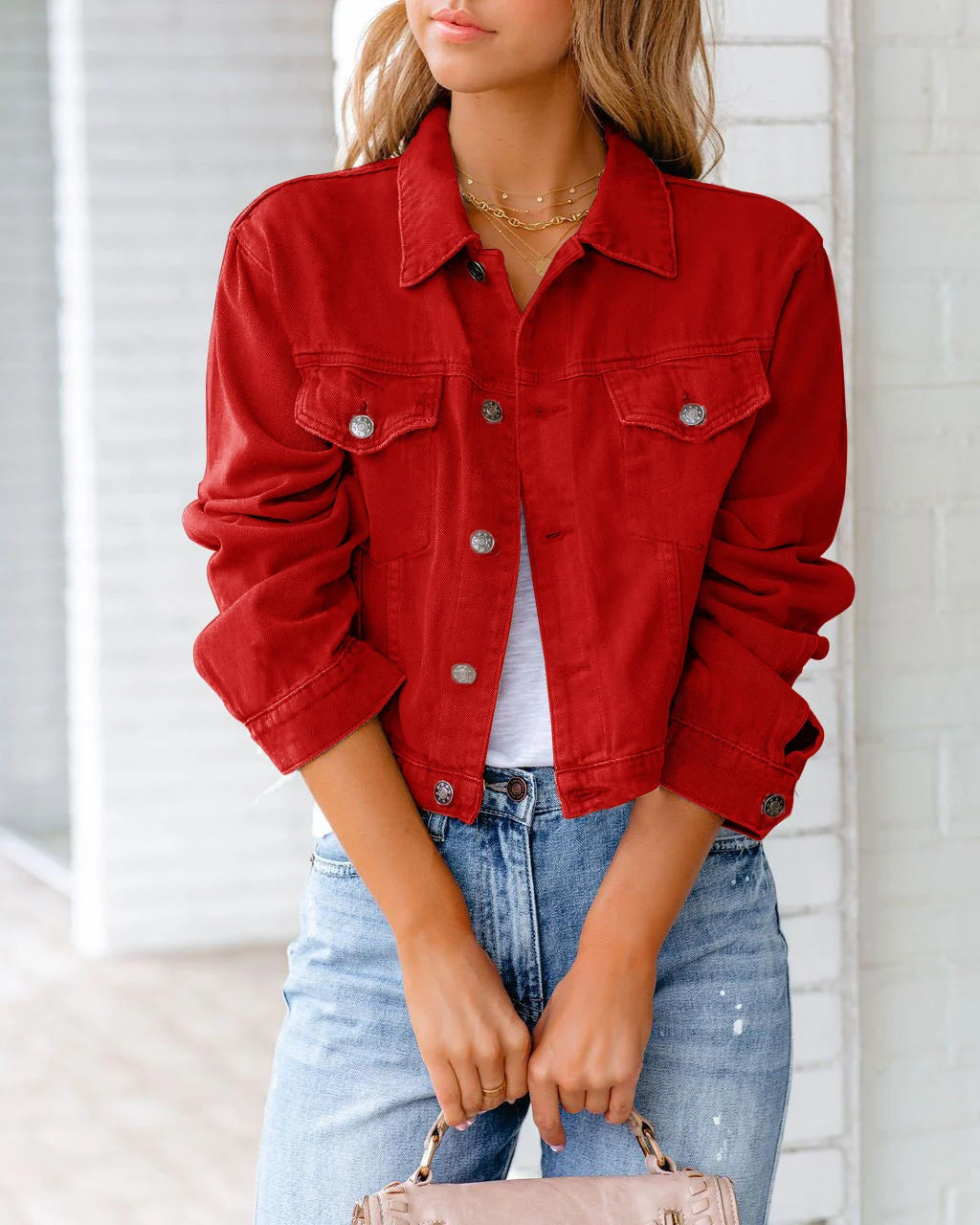 Women's cropped denim jacket styled over casual outfit, showing relaxed fit through body and sleeves