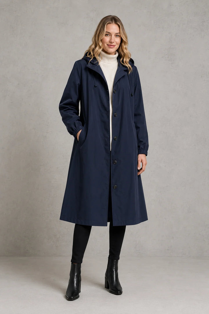 Women's hooded trench coat in light grey layered over cream jumper for spring outfits