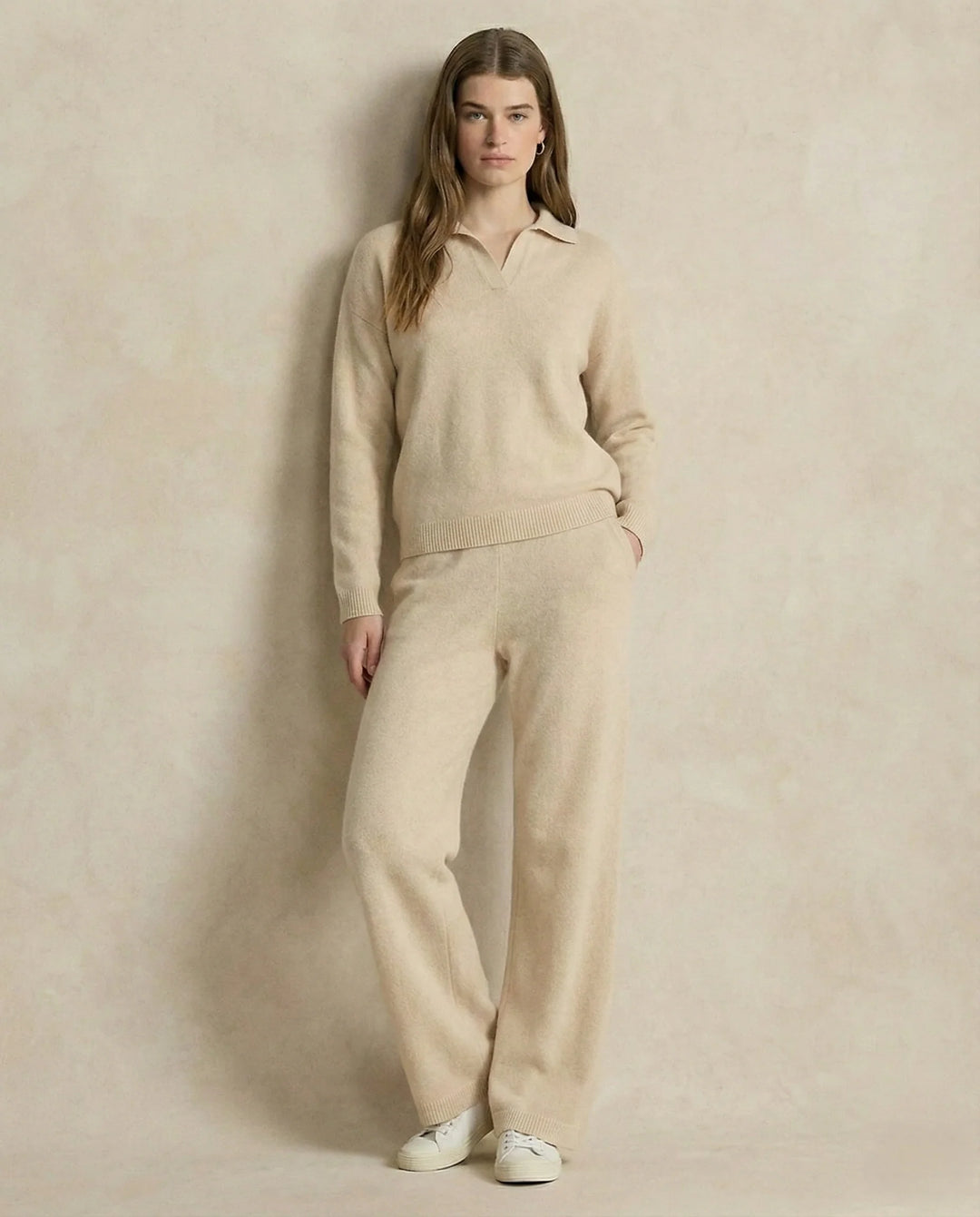 Woman seated in beige Merino lounge set with polo collar jumper and tapered trousers