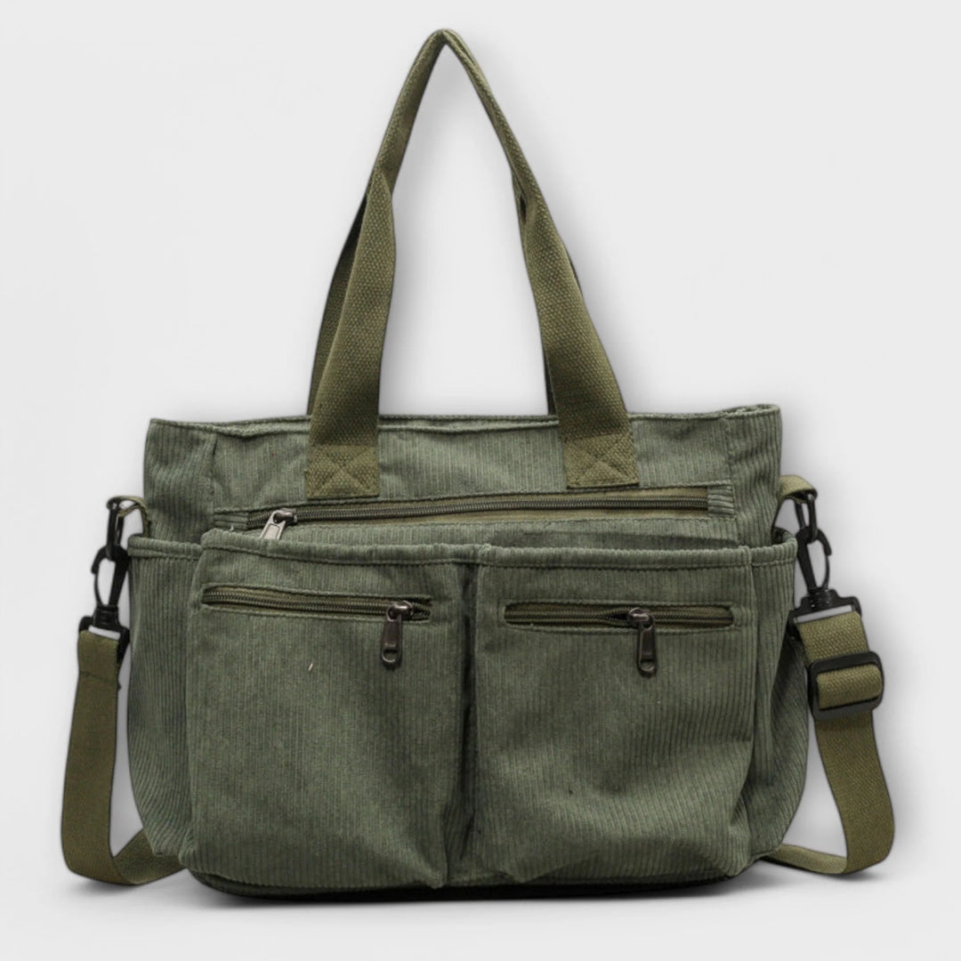 Front view of brown corduroy tote bag showing multiple zip pockets and structured silhouette