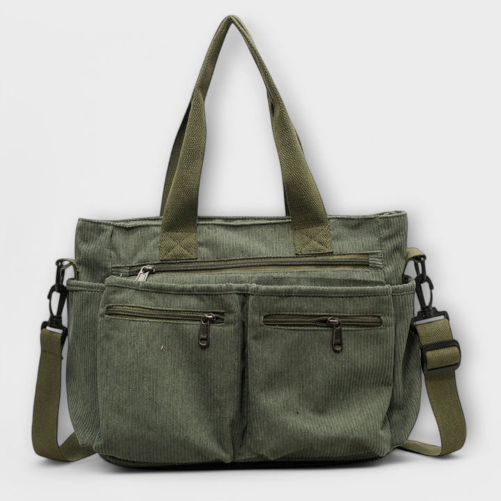 Front view of brown corduroy tote bag showing multiple zip pockets and structured silhouette