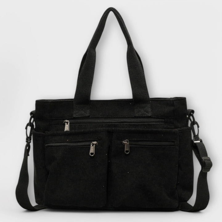 Side view of women's corduroy tote bag highlighting textured ribbed fabric and shoulder strap