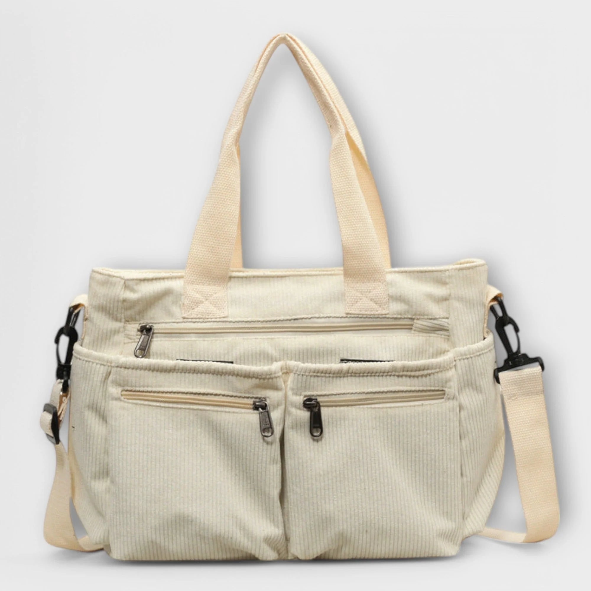 Detail of zip closure and front pockets on brown corduroy tote bag