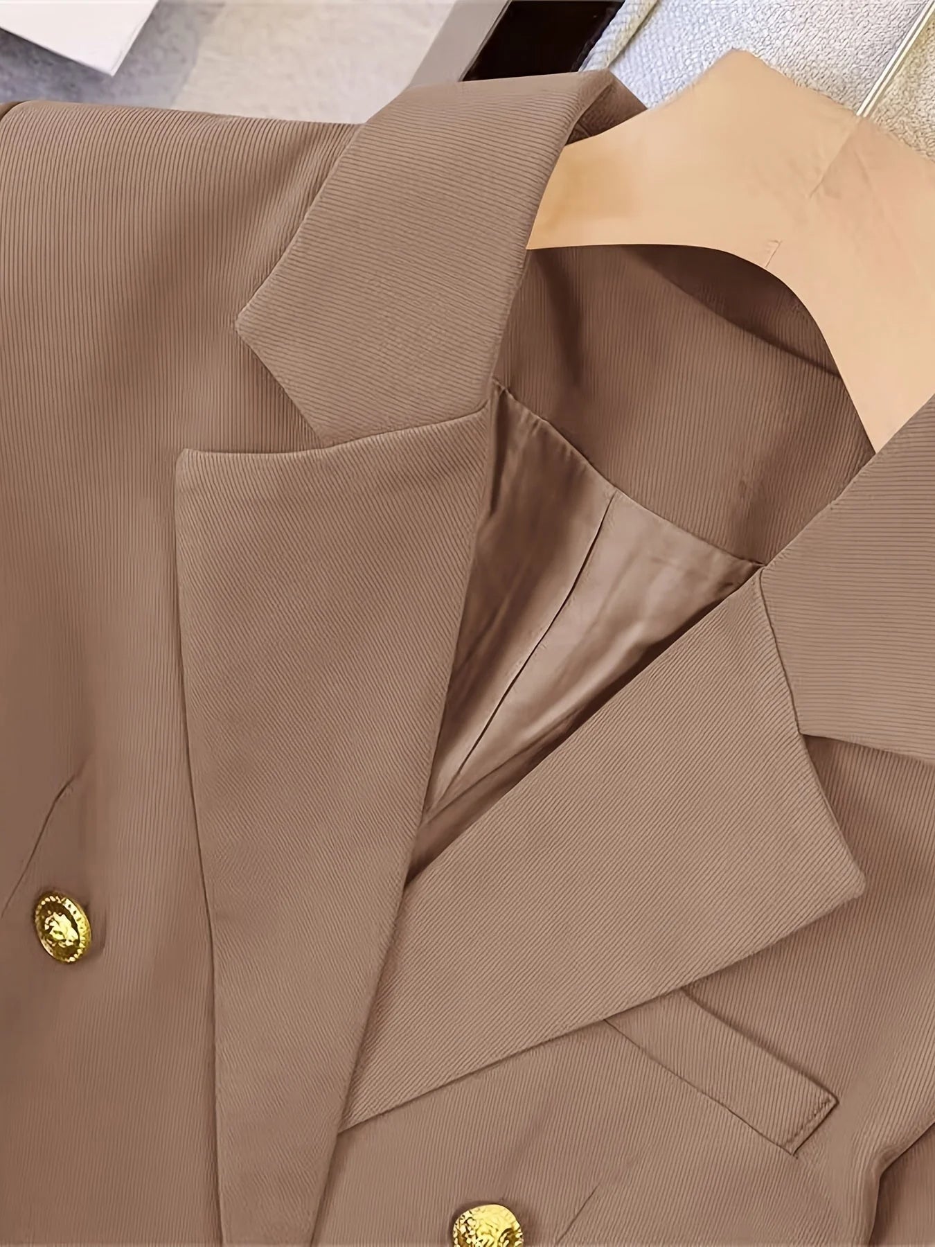 Detail shot of blazer front showing two rows of decorative gold-tone button placement