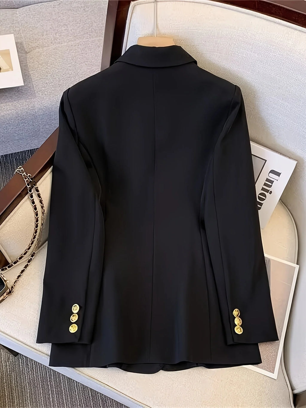 Close-up of double breasted blazer showing gold-tone button detailing and structured lapels
