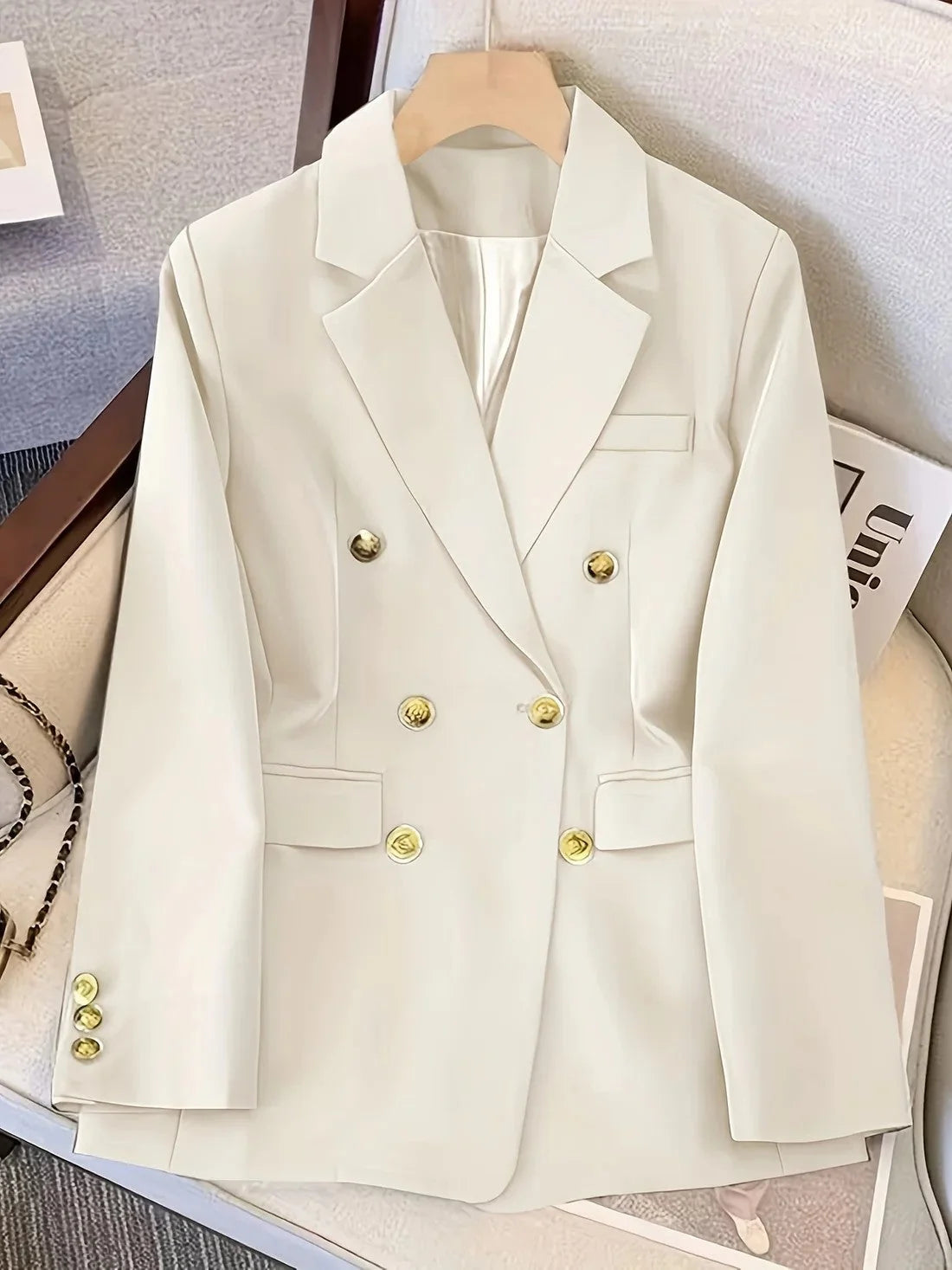 Women's double breasted blazer styled on hanger showing refined tailored silhouette