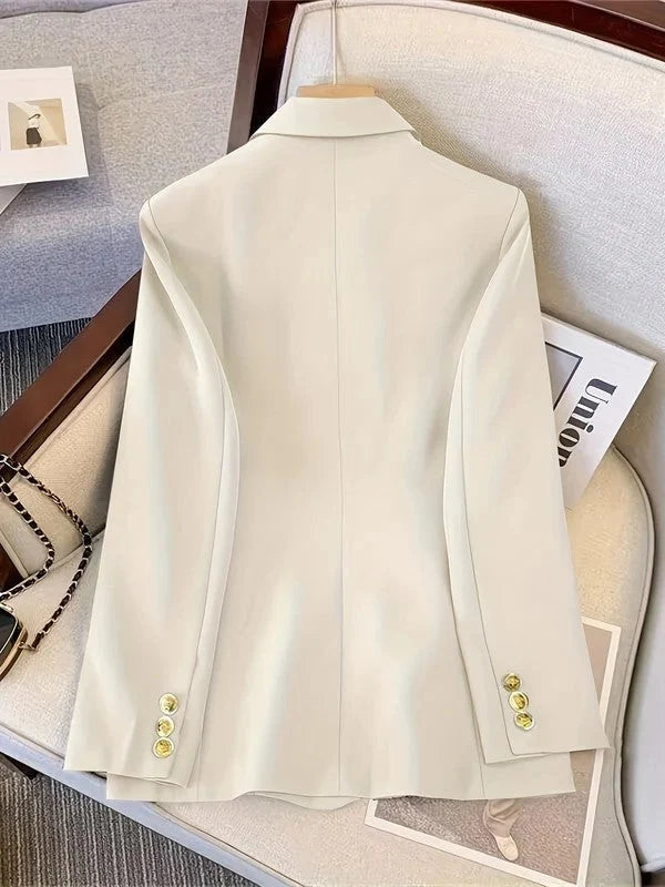 Detail of blazer sleeve cuffs with gold-tone button embellishments and structured finish