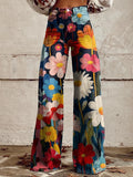 Women's wide-leg trousers with bold multicolour floral print on navy base and high-waist design