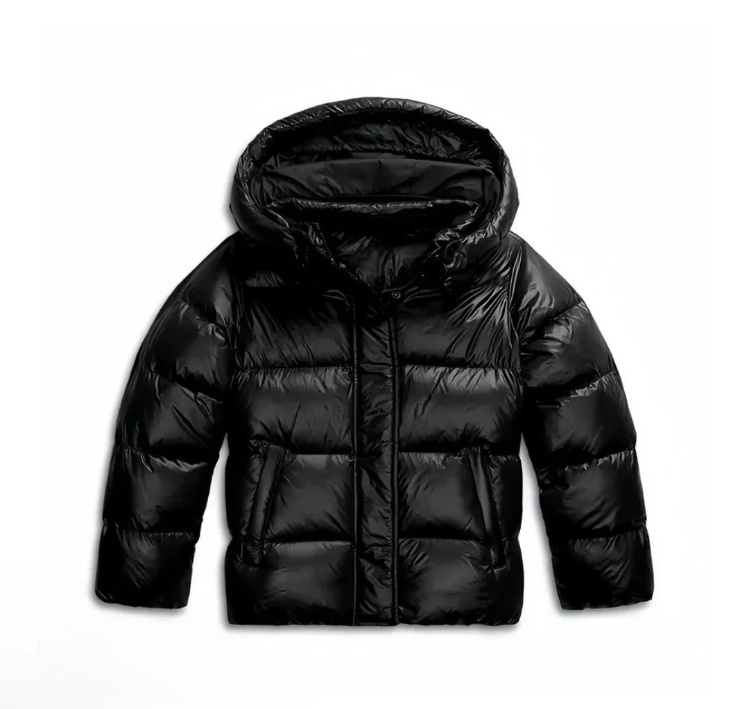 Detail of women's hooded puffer jacket glossy fabric and quilted panels