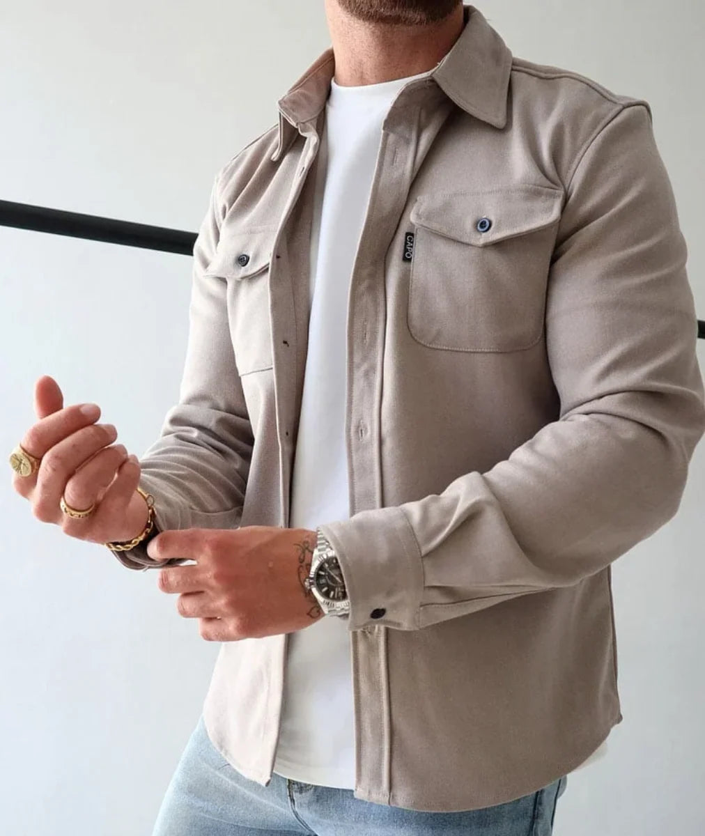 Man wearing beige men's overshirt jacket with collared neckline and chest pockets over white tee