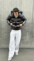 Men's puffer jacket in black with quilted design and hood, styled with grey joggers