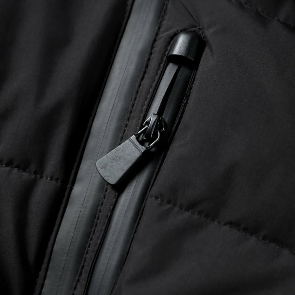 Detail of quilted puffer jacket with snap-button shoulder detailing and zip pockets