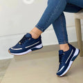 Side view of white lace-up trainers with chunky sole and metallic accent stripe