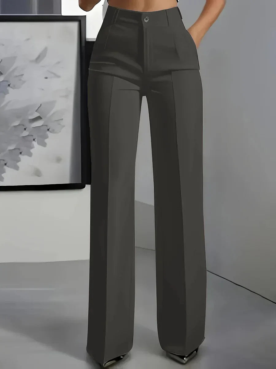 Close-up of high waist trousers waistband with single-button closure and pleated detailing