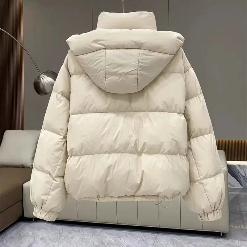 Women's oversized hooded puffer jacket showing relaxed silhouette and elasticated hem
