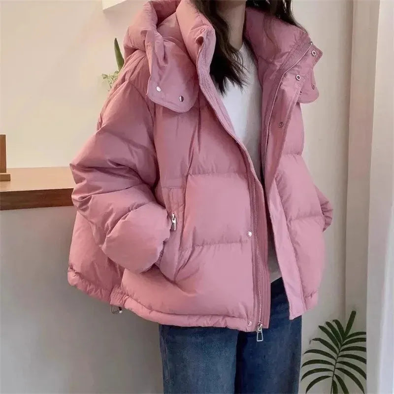 Side angle of women's black hooded puffer jacket with quilted panels and zip closure