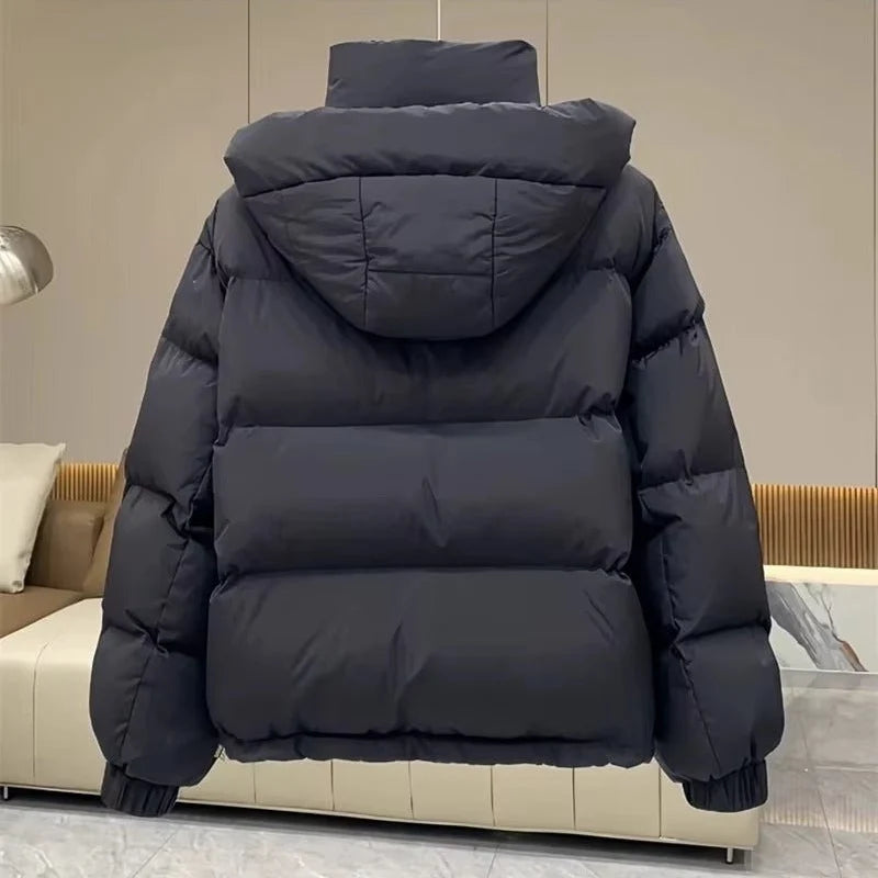 Side view of women's oversized hooded puffer jacket with elasticated cuffs and hem