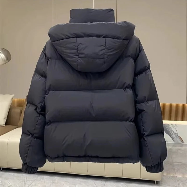 Side view of women's oversized hooded puffer jacket with elasticated cuffs and hem